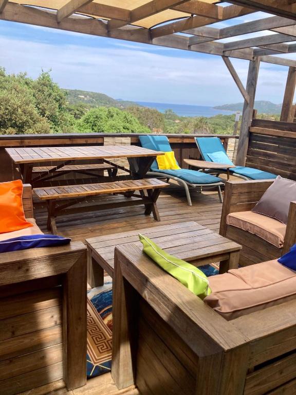 a deck with picnic tables and chairs on a roof at Appartement Cemiliana in Bonifacio