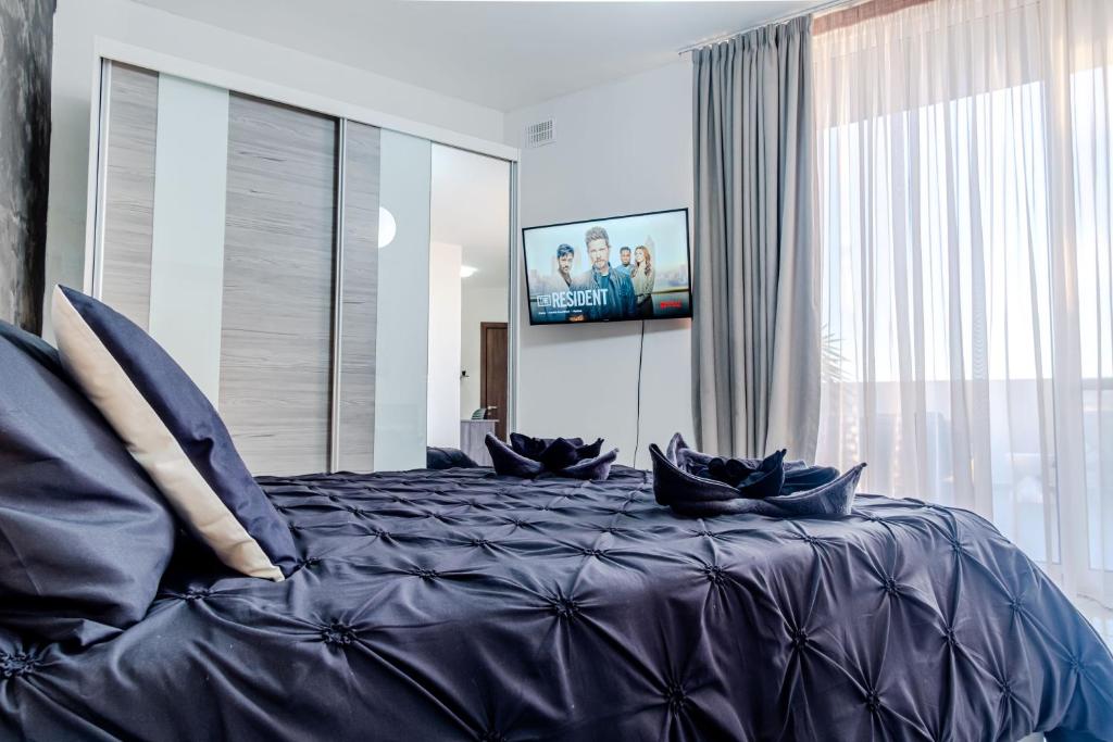 a bedroom with a large bed with blue pillows at D Pool Top in Msida