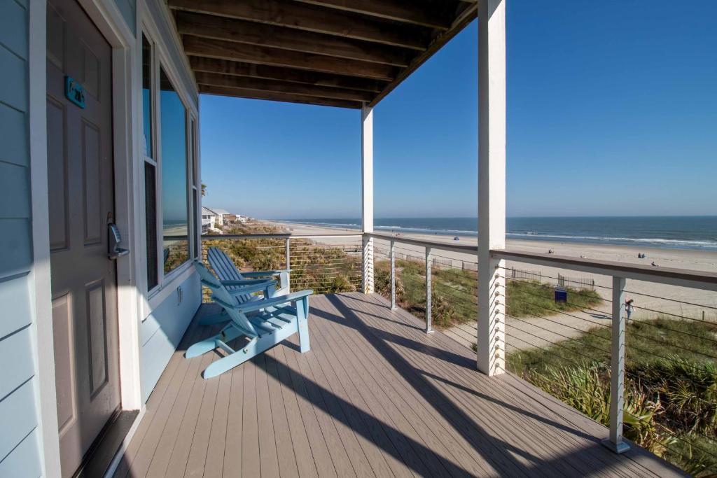 a porch with a blue bench on the beach at Little Peace of Heaven in Folly Beach
