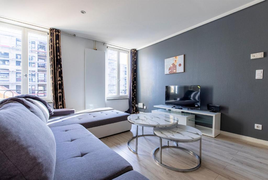 ein Wohnzimmer mit Couch und Fernseher in der Unterkunft Le Lagon Parking Un Séjour à Part in Longeville-lès-Metz