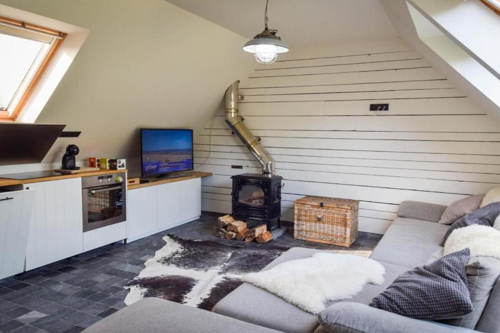 a living room with a couch and a stove at Barque de Furnes in Ieper