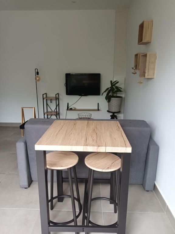 een tafel met twee krukken voor een bank bij Appartement st leu Vill'Alizoé in Entre-Deux