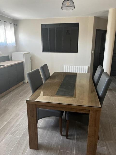 une table de salle à manger avec des chaises et une cuisine dans l'établissement Charming new independent apartment in a quiet area, à Saint-Pardoux-la-Rivière