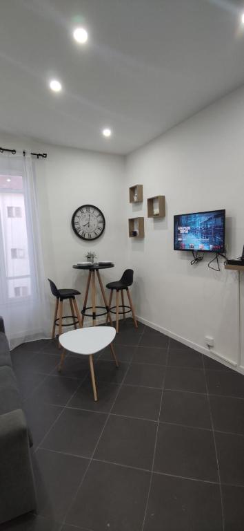 - un salon avec une table, des chaises et une télévision dans l'établissement Studio hyper centre Nice, à Nice