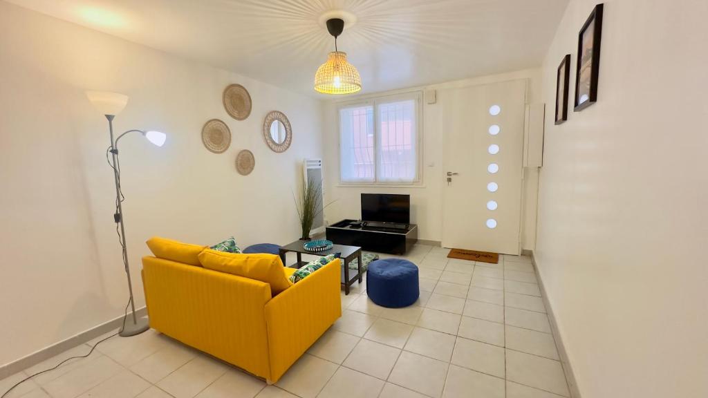 - un salon avec un canapé jaune et une télévision dans l'établissement 2 Bedroom Duplex Center, Patio, à Montpellier