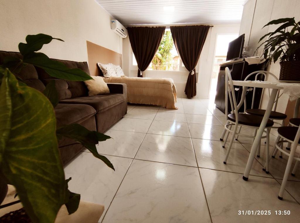 a living room with a couch and a table at Casa térrea, aos pés do Cristo! in Encantado