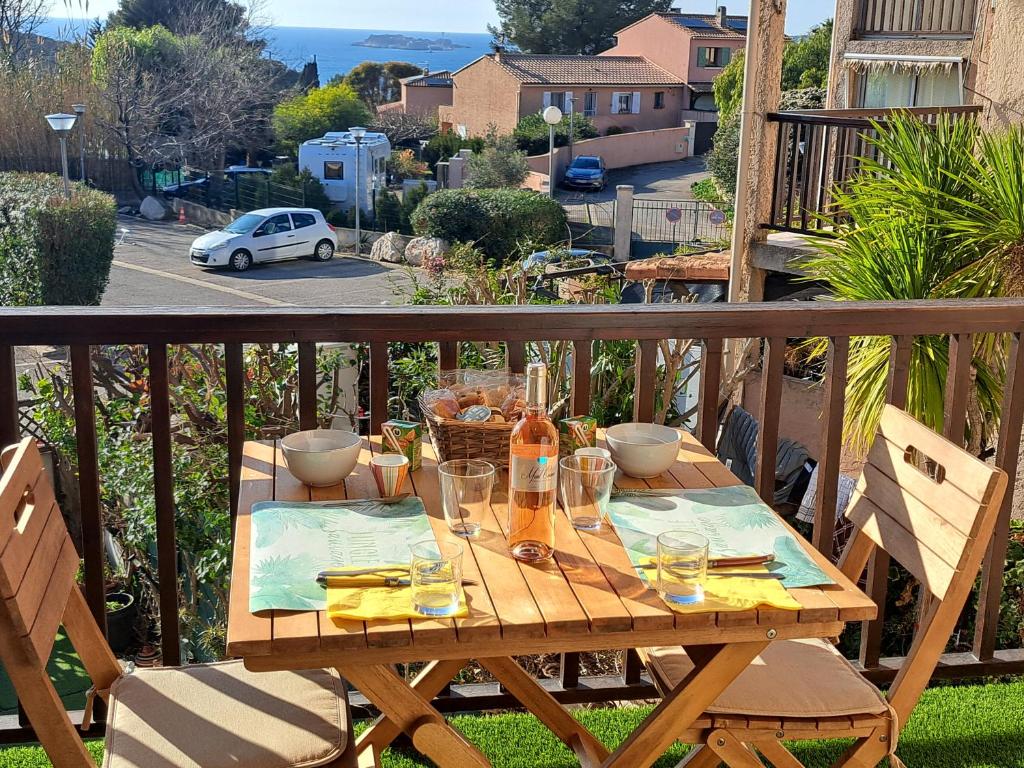 una mesa de madera con gafas en el balcón en Sanary Bandol plein SUD, en Sanary-sur-Mer