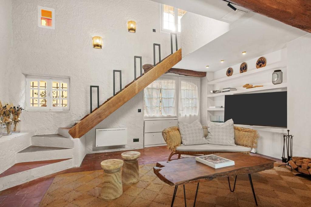 un salon avec un canapé et une télévision dans l'établissement Maison Gaï Soleil, à Grimaud