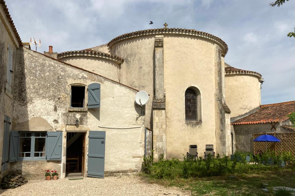 - un grand bâtiment en pierre avec des portes et des fenêtres bleues dans l'établissement Bumblebee Cottage, à Vouillé-les-Marais