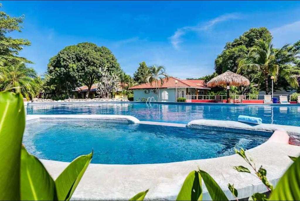 a swimming pool with a house in the background at Couples Tropical Getaway with Pool, Playa Potrero in Potrero
