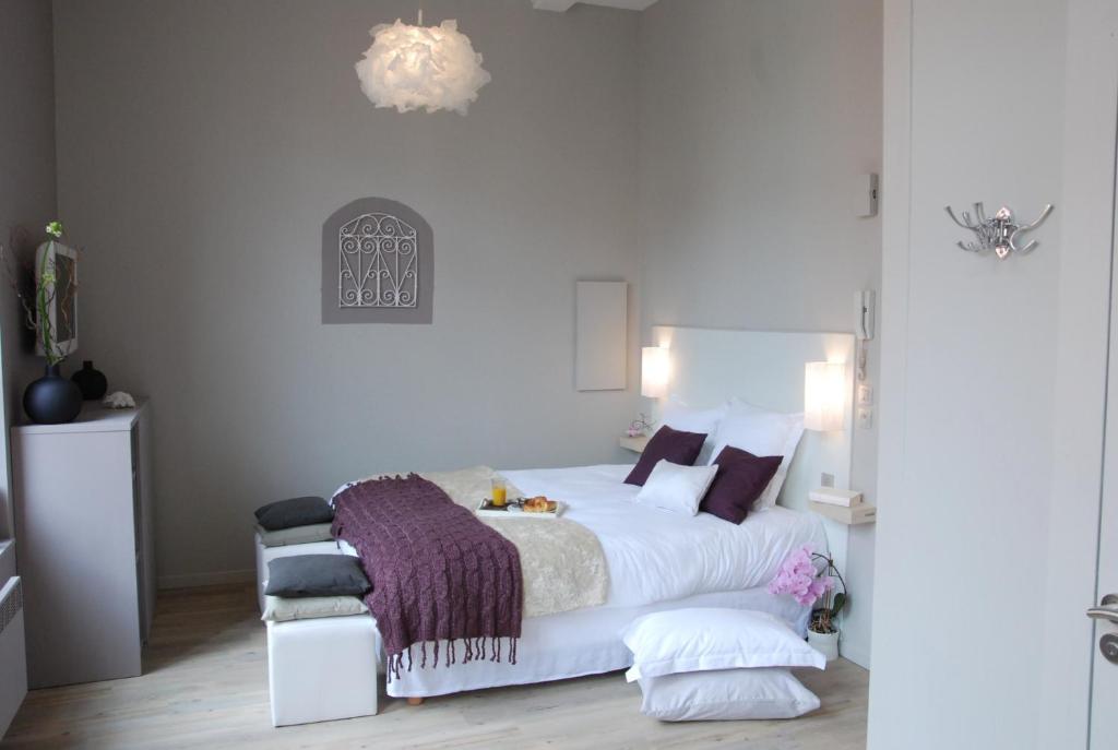 1 dormitorio con 1 cama blanca grande y 1 silla en Lille A Part - Gites Urbains, en Lille