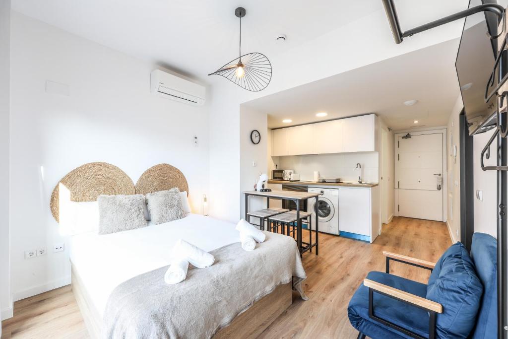 Elegant Studio with Private Terrace by RentitUP في سان سيباستيان دي لوس رييس: غرفة نوم مع سرير كبير ومطبخ