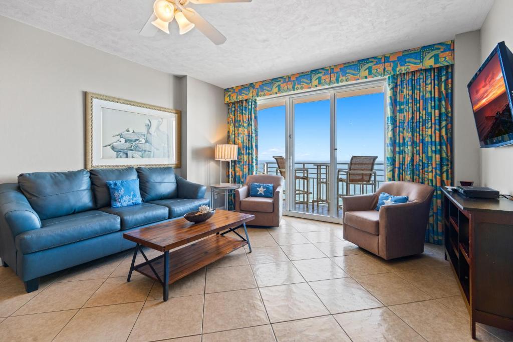een woonkamer met een blauwe bank en stoelen bij Marvelous Oceanfront 12th Floor 3BR Retreat at The WyndhamOcean Walk Resort in Daytona Beach