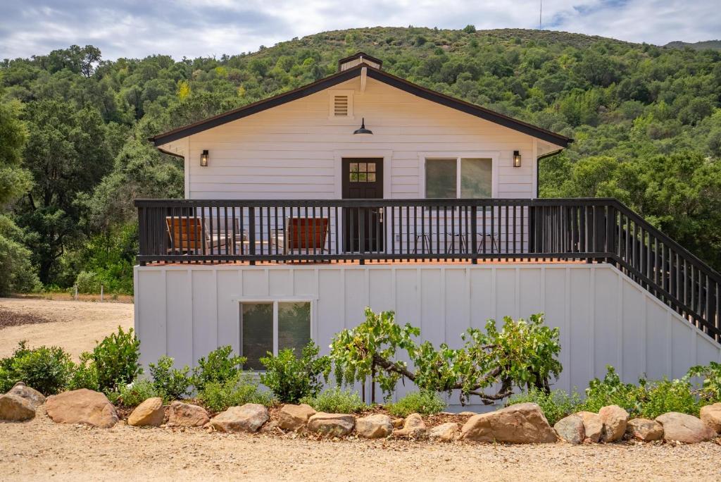 a house with a balcony on top of it at Stampede Loft at The 8 Mile in Santa Margarita