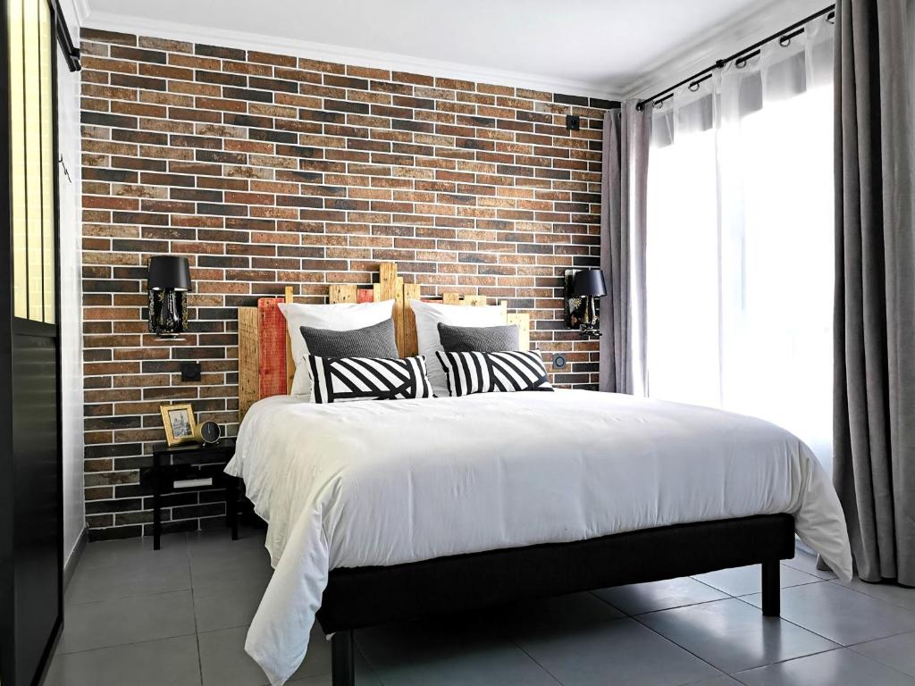 une chambre avec un mur de briques et un grand lit dans l'établissement Studio industriel cosy à 1 min du Vieux-Port Calme & Tout équipé, à Marseille