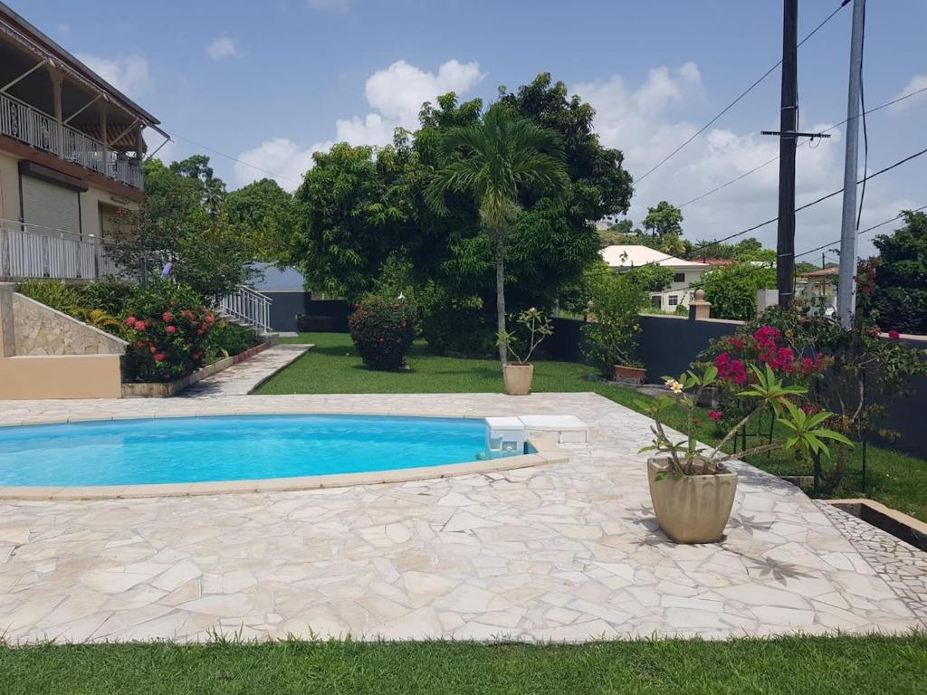 a swimming pool in the yard of a house at Joli bas-de-villa in Les Abymes