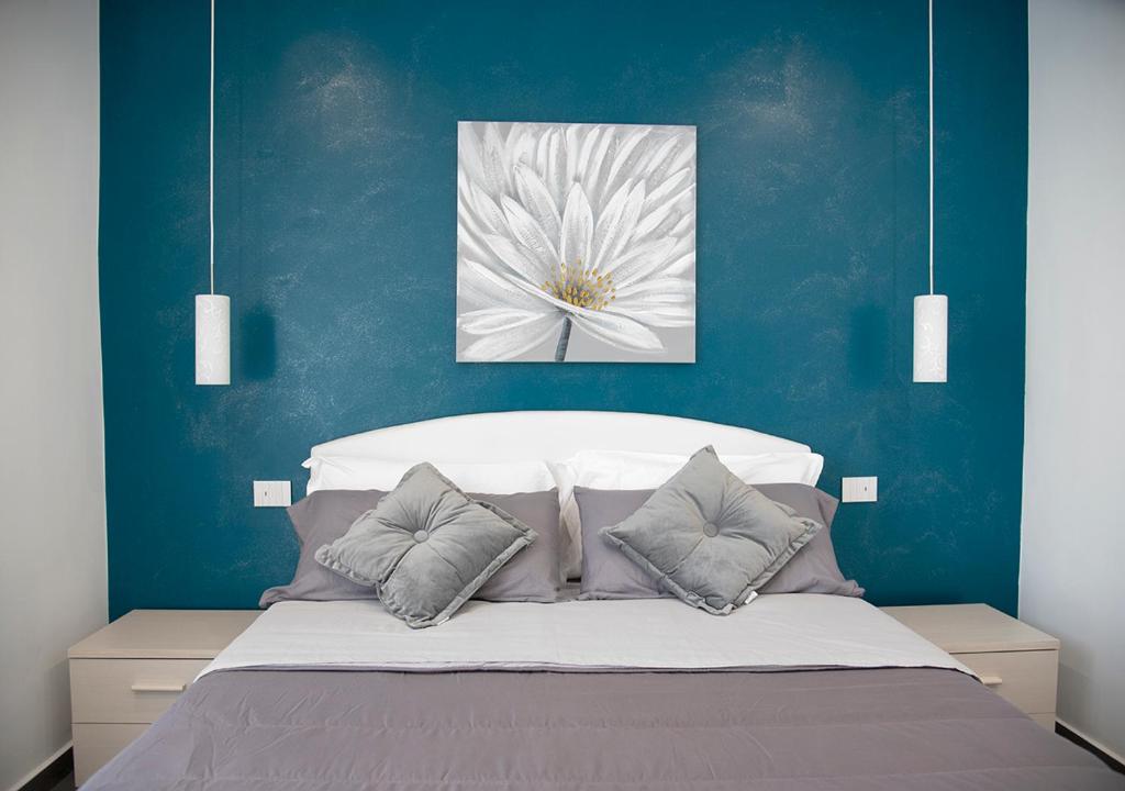 サンタ・ヴェネリーナにあるLa Rosa dell'Etna - Apartmentsのベッドルーム1室(ベッドの上に白い花の絵付)