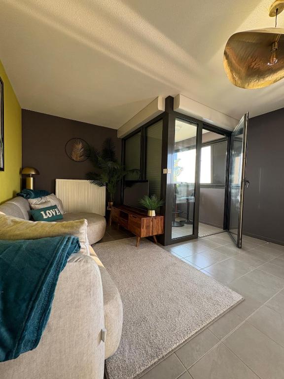 - un salon avec un canapé et des portes en verre dans l'établissement Appartement unique, coloré en Citadelle, à Dunkerque