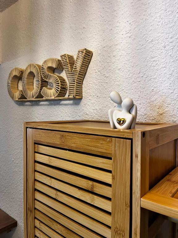 a sign that says love sitting on top of a wooden cabinet at Studio le Cosy - Bourgoin Centre in Bourgoin