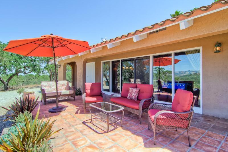 a patio with chairs and umbrellas and a table at Las Palmas in Templeton