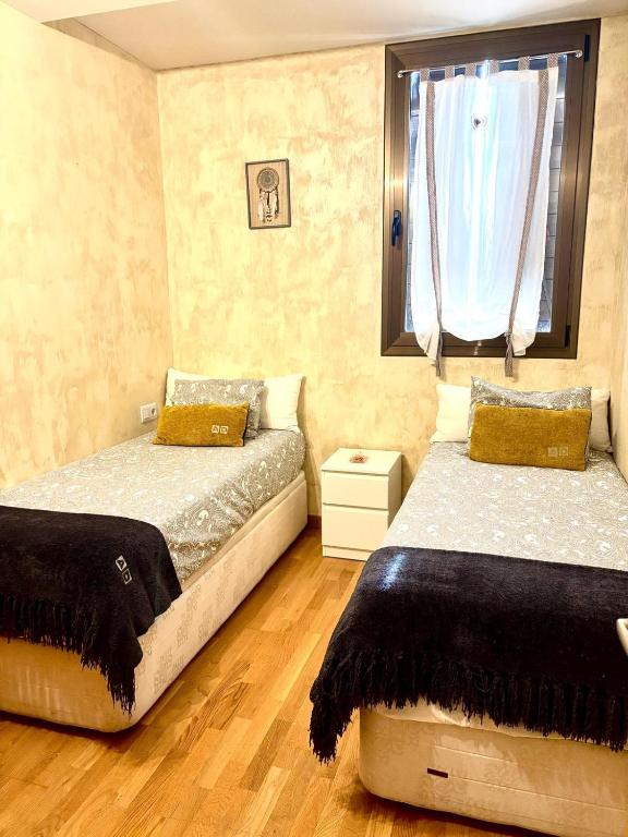 a bedroom with two beds and a window at APARTAMENTO L AÜT in Pla de l'Ermita