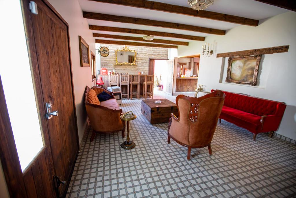 un soggiorno con sedie e un divano rosso di Hotel Estancia 1928 a Zacatlán