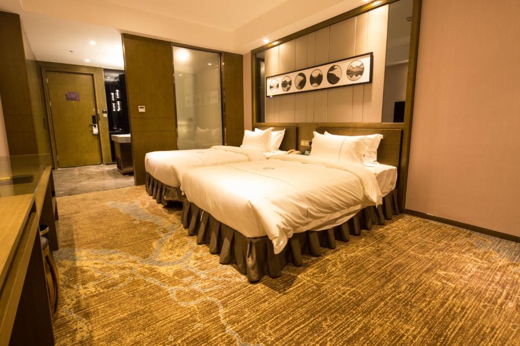 Postel nebo postele na pokoji v ubytování lnsail Hotel Shenzhen Luohu Port Railway Station