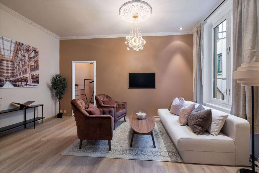 オスロにあるDINBNB Apartments Enjoy a stylish stay in the heart of the cityのソファと椅子2脚のあるリビングルーム