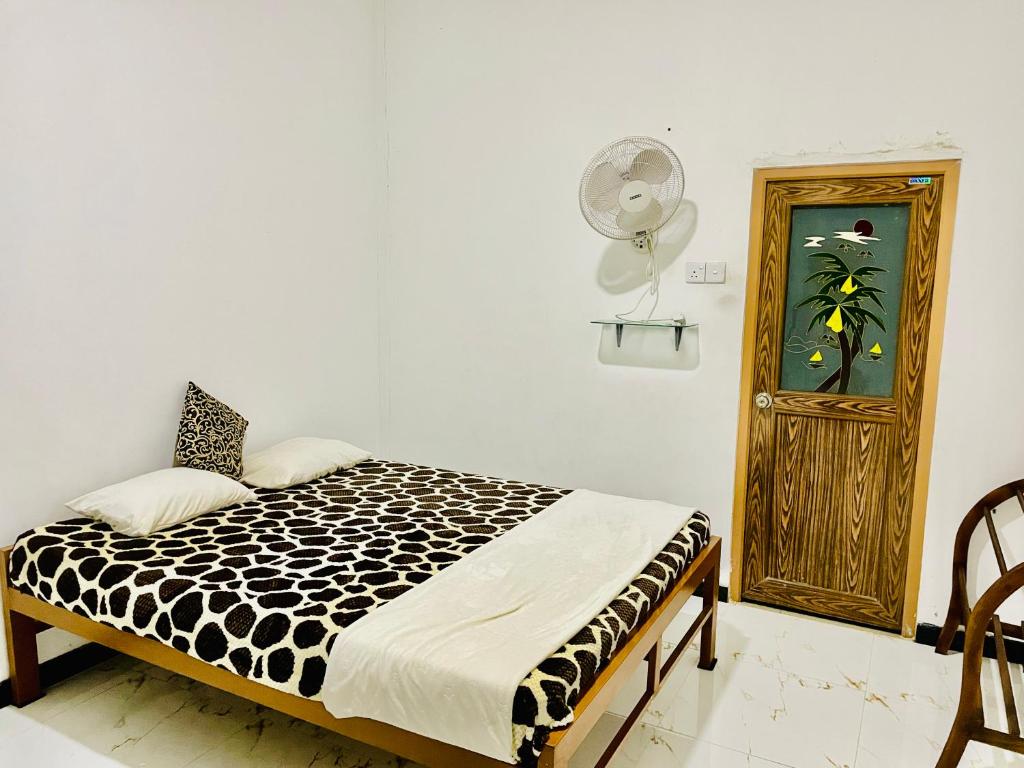 una camera da letto con un letto con un piumone bianco e nero di The Safari Rest Stop a Udawalawe