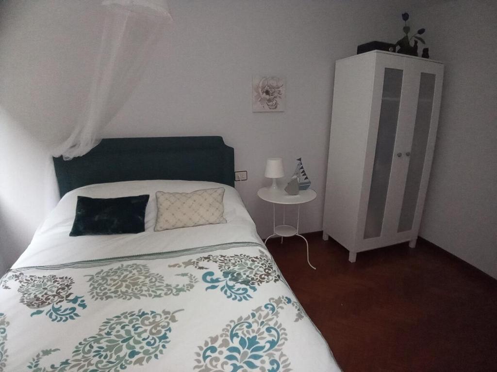 een slaapkamer met een bed en een nachtkastje bij Espiguiñas in Muros