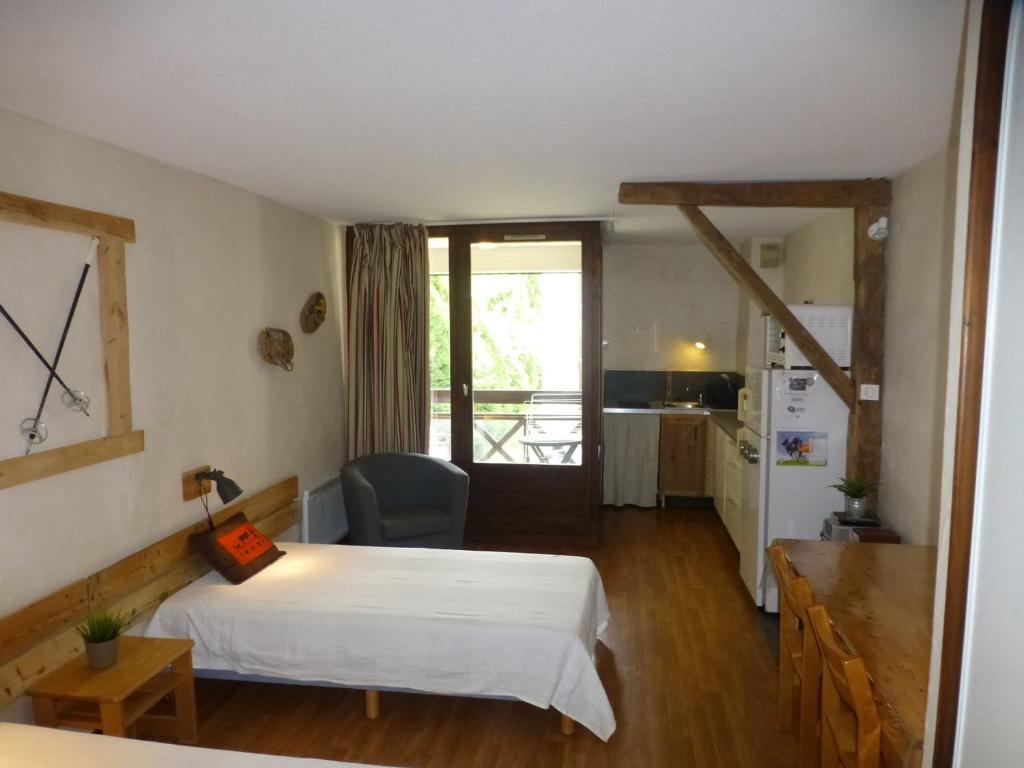 une chambre d'hôtel avec un lit et une cuisine dans l'établissement Studio lumineux 2* avec balcon, parking et WIFI - 4 pers, proche thermes, calme assuré - FR-1-512-223, à Brides-les-Bains