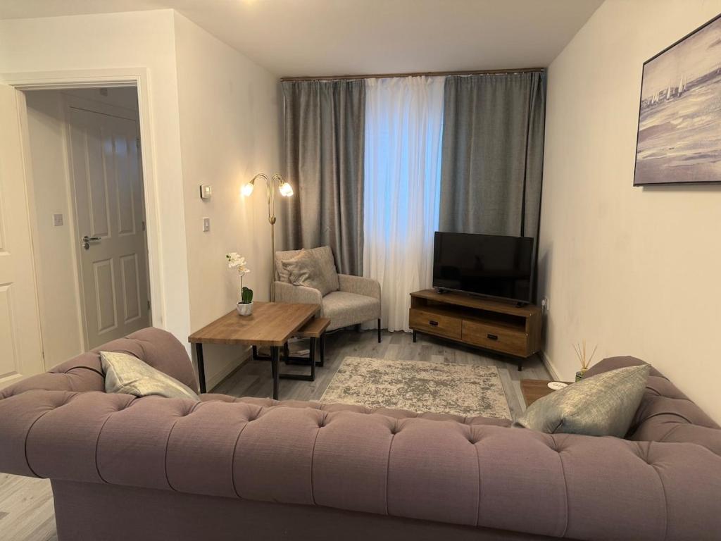 Una sala de estar con un sofá y un televisor. en Stunning 3 bed house - Wantage, en Wantage