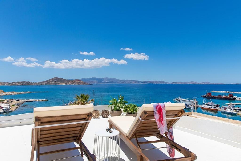 un par de sillas sentadas en un balcón con vistas al océano en Dream House in the Venetian Castle, en Naxos Chora