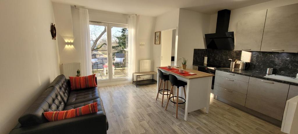 un salon avec un canapé et une cuisine dans l'établissement Cap soleil, à Dammarie-les-Lys