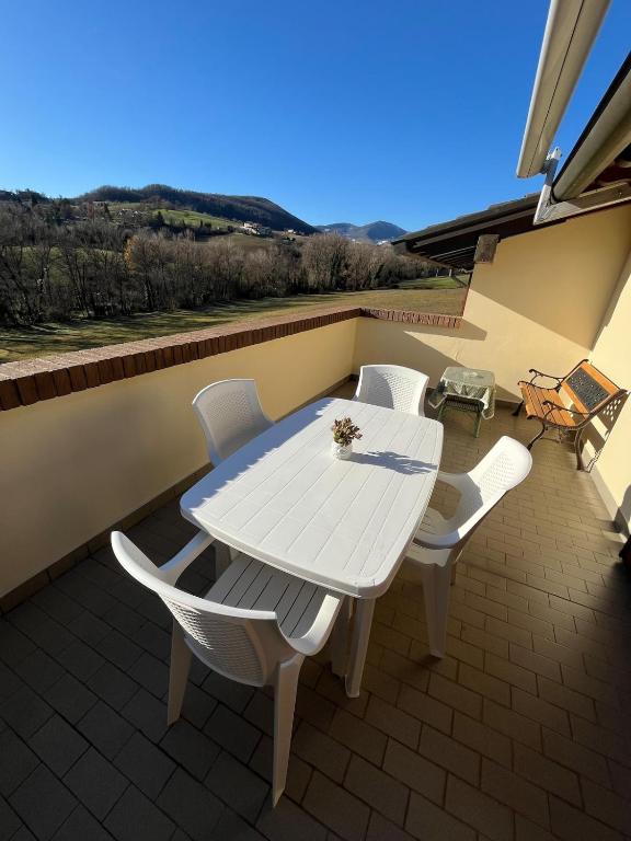 a white table and white chairs on a patio at La Fabiola in Langhirano