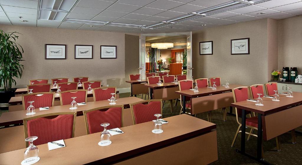 a dining room with tables and red chairs at Coast Gateway Hotel in SeaTac