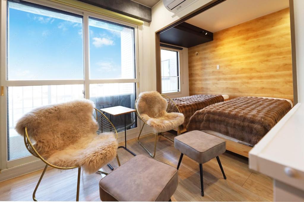 a room with two beds and chairs and a window at Utopia 21 - Vacation STAY 17955 in Sapporo