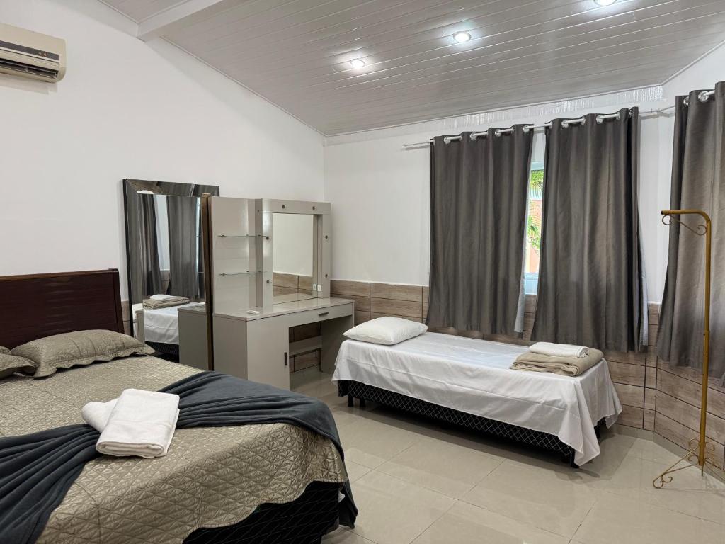 - une chambre avec 2 lits, un lavabo et un miroir dans l'établissement Le Partie, à Angra dos Reis