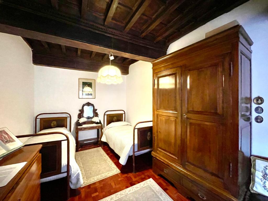 een slaapkamer met 2 bedden en een houten kast bij B&B Souvenirs d'Antan in Orvinio