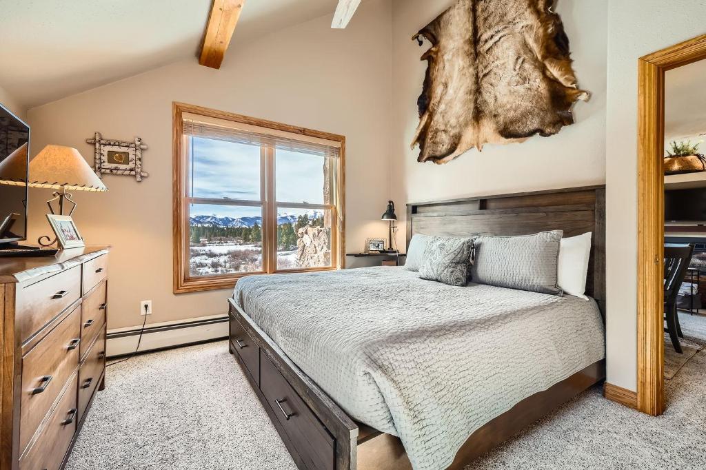 ein Schlafzimmer mit großem Bett und Fenster in der Unterkunft 5959 Hidden River Lodge condo in Keystone