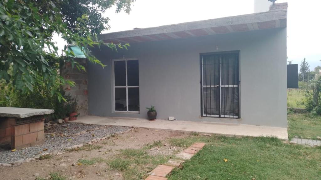 a white house with a gate in a yard at Villarrica in Valle Hermoso