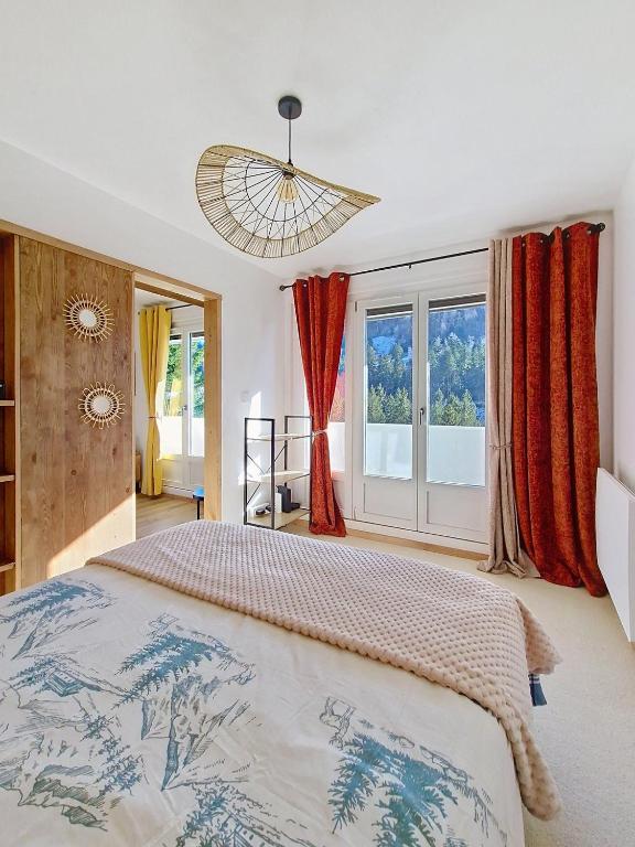 une chambre avec un grand lit et une grande fenêtre dans l'établissement La Bresse Nature and Glisse, à La Bresse