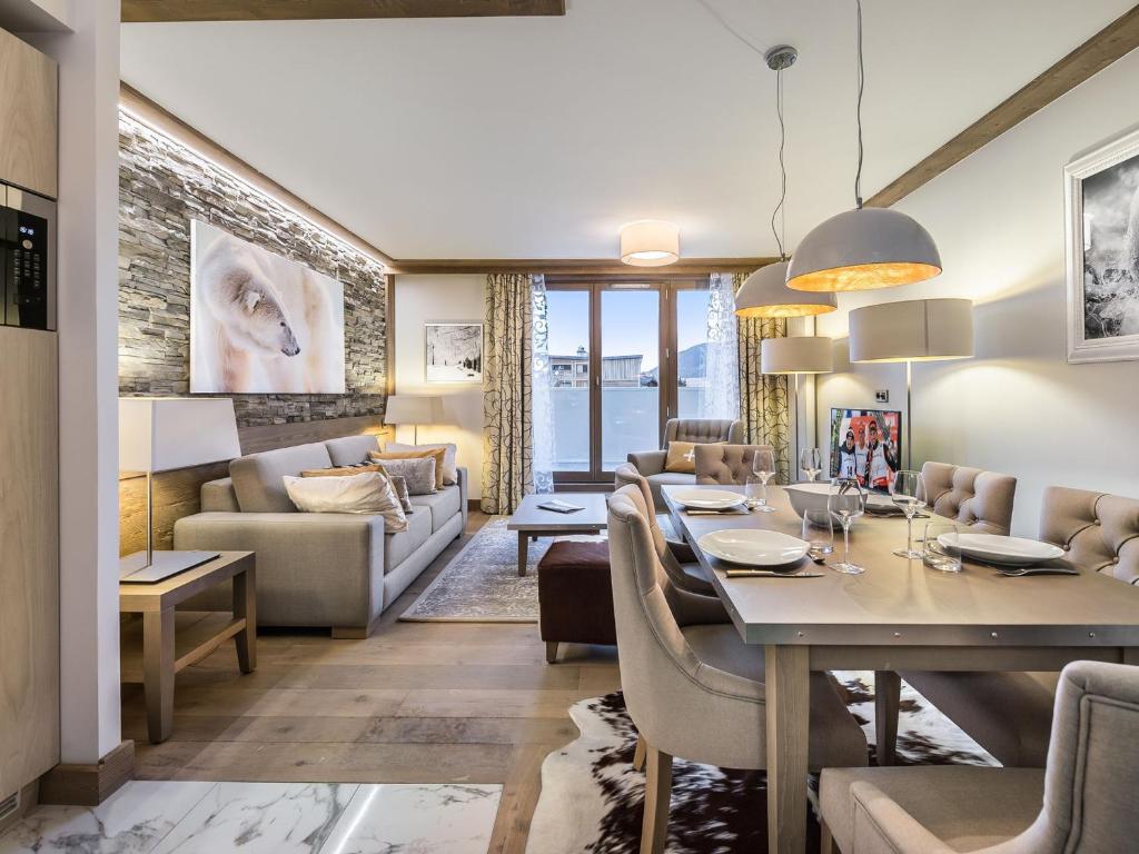 ein Esszimmer und ein Wohnzimmer mit Tisch und Stühlen in der Unterkunft Appartement élégant avec accès facile aux pistes, parking et salle de fitness - FR-1-562-23 in Courchevel