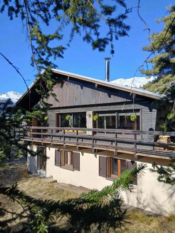 une maison avec une grande terrasse sur le côté dans l'établissement chalet LES GRANDES TERRES, à Enchastrayes
