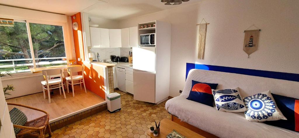 un petit salon avec un canapé et une cuisine dans l'établissement Studio 4 pers, cosy ,3mn mer, parking, à La Grande Motte