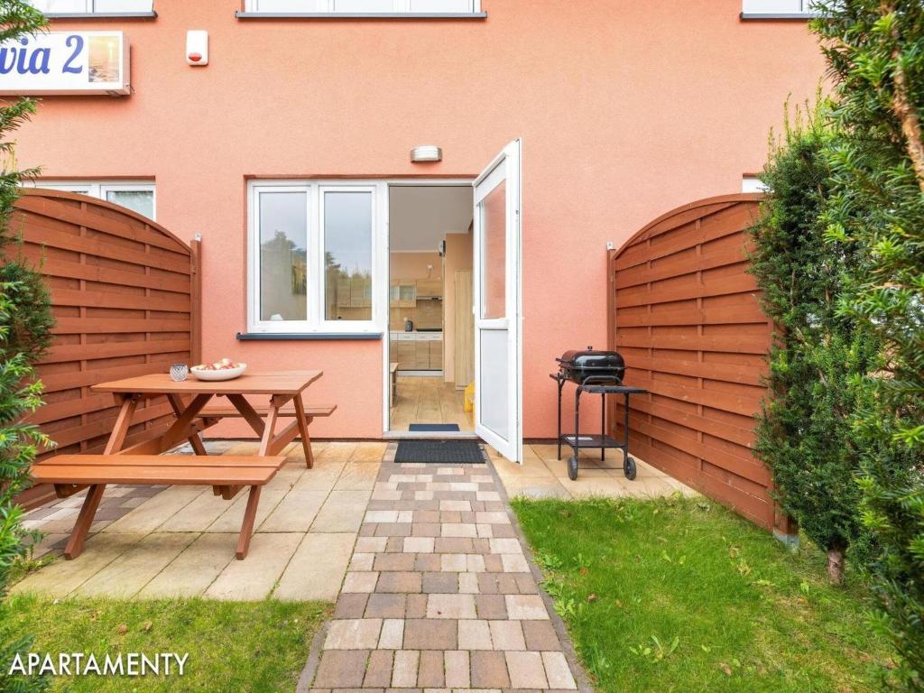 patio ze stołem i ławką przed budynkiem w obiekcie 2-level holiday apartments, Niechorze w mieście Niechorze