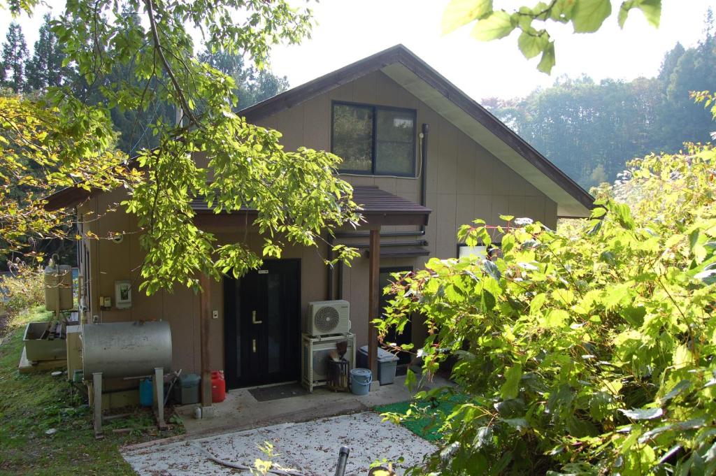 a house with the door open in a yard at Chalet 別邸しろうま in Hakuba