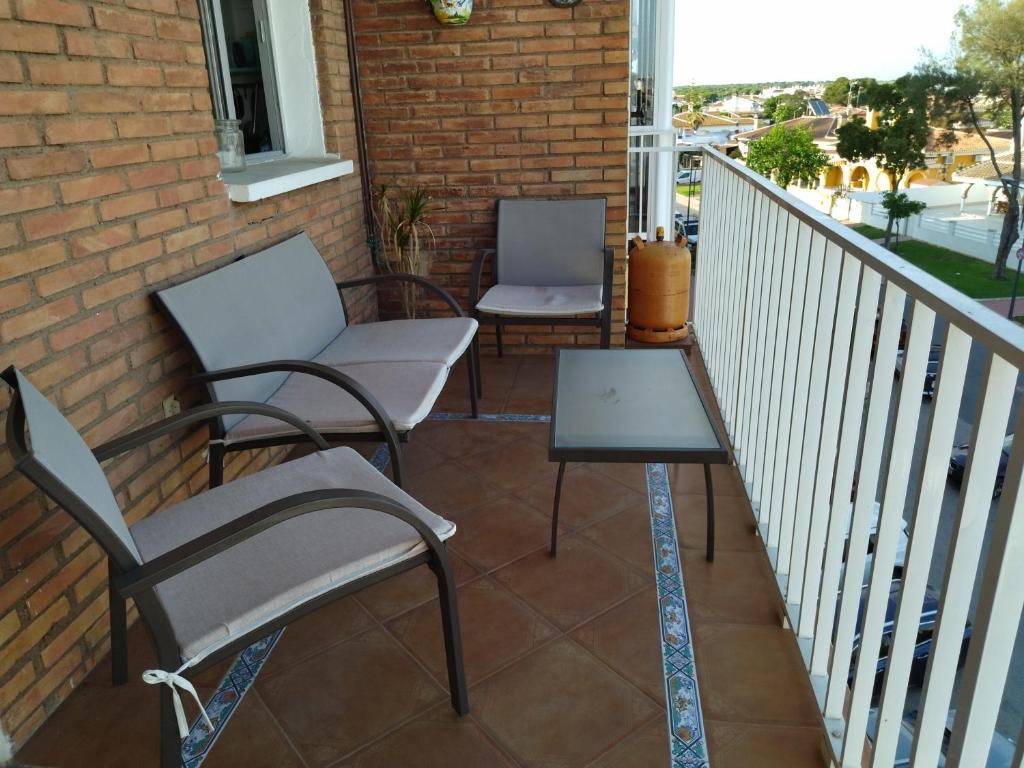 two chairs and a table on a balcony at Apartamento Virgen de la Sierra in Matalascañas