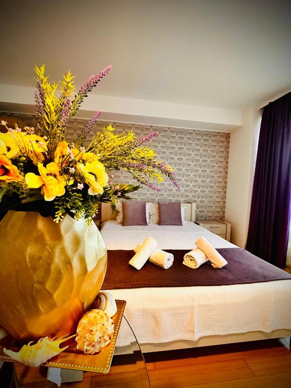 a bedroom with a bed and a vase of flowers at Lira Beach Studio in Mamaia
