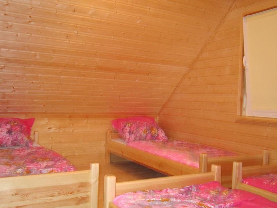 a room with two beds in a cabin at Domki Letniskowe Oaza Wicie in Wicie